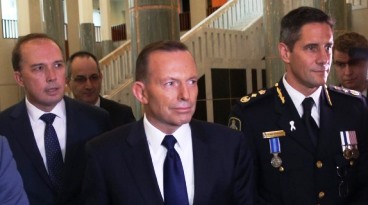 Dunce Abbott flanked by Minister Peter Dutton and uniformed ABF spokesperson